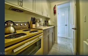 a kitchen with a stove with a tea kettle on it at Les Maisons Montcalm in Quebec City