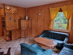 een woonkamer met een bank en een tafel bij WILIMY Dom nad jeziorem Dadaj in Wilimy +30 foto's