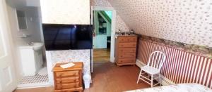 a small room with a bed and a dresser and a chair at Bulwinkles Place B&B in Souris