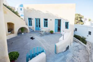 un patio con una sedia blu di fronte a una casa di Santorinio Yellow House a Éxo Goniá