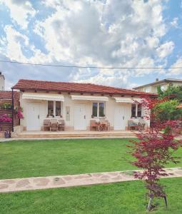 une maison avec une cour verdoyante devant elle dans l'établissement Apartments Three Ohrid, à Ohrid