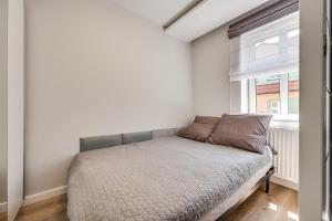 a small bed in a room with a window at Central Platinum Apartments 15 in Rybnik