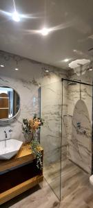 een badkamer met een wastafel en een spiegel bij Costa ANASTASIA_sea view suites in Nea Vrasna