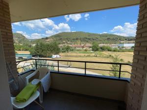 a balcony with a view of a field and mountains at Duplex tres habitaciones Pirineo in Boltaña