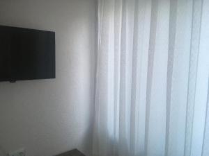 a room with a curtain and a television on a wall at Salda Lake Sagiroglu Apart in Gökçe +10 photos