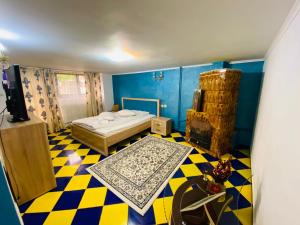 a bedroom with a bed and a checkered floor at Casa Petrișor in Corbi