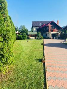 a grassy yard with a house in the background at Casa Petrișor in Corbi