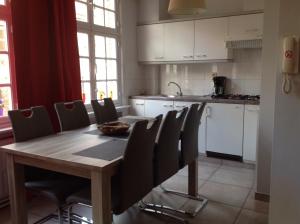cocina con mesa de madera y sillas en Holiday Home 't Beertje, en Brujas