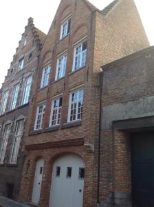 un grand bâtiment en briques avec des portes blanches et un garage dans l'établissement Holiday Home 't Beertje, à Bruges