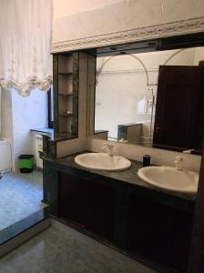 a bathroom with two sinks and a large mirror at Bettyhome in Cariati