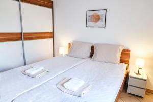 um quarto com uma cama branca com duas toalhas em Hiša Ivančič em Šared