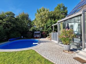 a swimming pool in a yard next to a house at Ferienwohnung Heinze in Eilenburg