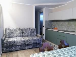 a living room with a couch and a kitchen at Appartamento Condominio Carlo Magno Folgarida Alta in Folgarida