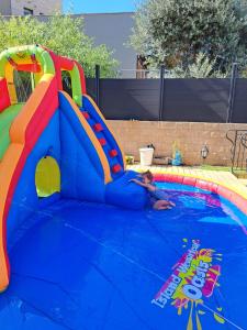 Sha‘alvimGalit's Zimmer的一名小孩在游泳池滑滑滑梯