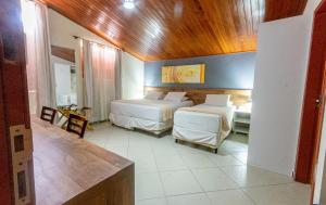 a bedroom with two beds and a wooden ceiling at Serra Golfe Apart Hotel in Bananeiras