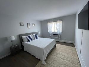 a white bedroom with a bed and a window at Ocean Surf Resort in Montauk