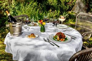 - une table avec des assiettes de nourriture et une bouteille de vin dans l'établissement Hostellerie du Chateau Bellenaves, à Bellenaves