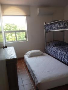 1 dormitorio con 2 literas y ventana en Camino al Mar en Santa Cruz - Huatulco