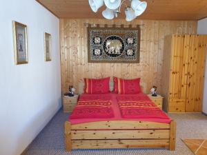 a bedroom with a large wooden bed with red pillows at Glückselefant 01 in Heringsdorf