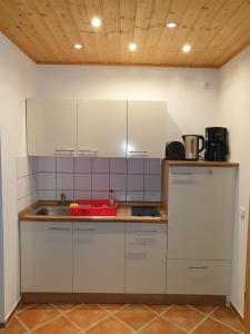 a kitchen with white cabinets and a sink at Glückselefant 01 in Heringsdorf