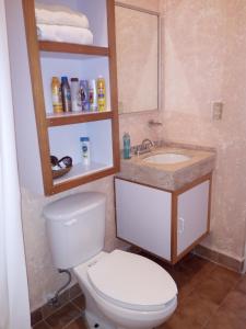 a bathroom with a toilet and a sink at Camino al Mar in Santa Cruz Huatulco +14 photos