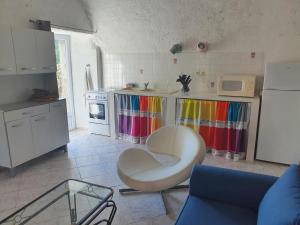 eine Küche mit einem weißen Stuhl und einem Kühlschrank in der Unterkunft English Club in Corsica A in Porri