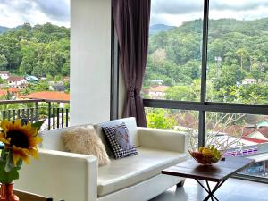 een woonkamer met een witte bank en een groot raam bij Icon park phuket condo in Phuket