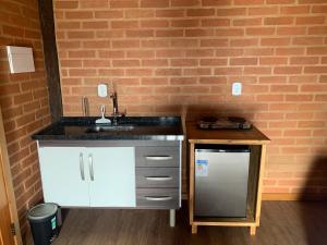 eine Küche mit Spüle und Arbeitsplatte in der Unterkunft chalés Roma in Santo Antônio do Pinhal