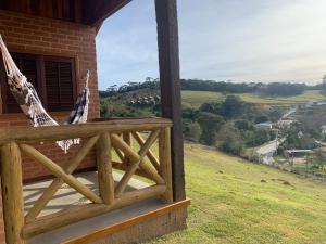 eine Veranda eines Hauses mit einer Hängematte darauf in der Unterkunft chalés Roma in Santo Antônio do Pinhal + 7 Fotos