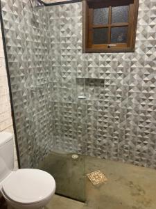 a bathroom with a shower with a toilet and a window at chalés Roma in Santo Antônio do Pinhal +3 photos