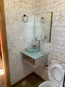 ein Badezimmer mit Waschbecken und Toilette in der Unterkunft chalés Roma in Santo Antônio do Pinhal