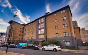 a large brick building with cars parked in front of it at BAI HOUSE in London