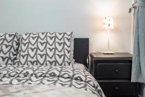 a bedroom with a bed and a lamp on a night stand at Adorable 1-bedroom suit with independent entrance in New Westminster