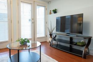 a living room with a television and a glass table at Adorable 1-bedroom suit with independent entrance in New Westminster