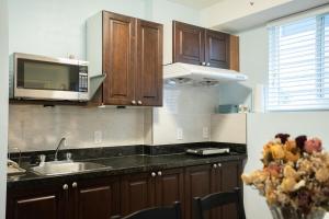 a kitchen with a sink and a microwave at Lovely 1BR Secondary suite with Separate entrance in New Westminster