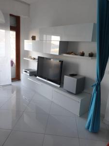 a living room with a flat screen tv on a wall at appartamento openspace fronte mare esclusivo due letti matrimoniali a Portovenere in Portovenere