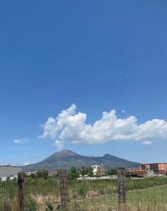 a mountain in the distance with a fence in the foreground at Mary House in Pompei