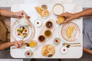 twee mensen aan een tafel met borden eten bij Riad Nyla Wellness and Spa in Marrakesh