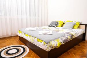 a bedroom with a bed with yellow and gray pillows at Krichim Apartments,Three-Bedroom, large apartment, TOP CENTER in Sofia