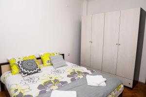 a bedroom with a bed with yellow and gray pillows at Krichim Apartments,Three-Bedroom, large apartment, TOP CENTER in Sofia