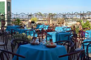 a group of tables and chairs with blue tables at Riad Selma in Meknès