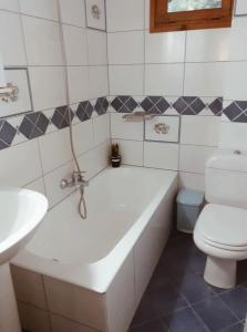 a bathroom with a tub and a toilet and a sink at Andreas Village 2 in Achladies