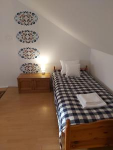 a bedroom with a bed with a black and white checkered blanket at Pokoje Podzamcze in Stare Drawsko