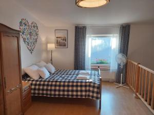 a bedroom with a bed and a window with a fan at Pokoje Podzamcze in Stare Drawsko