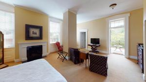 Schlafzimmer mit einem Bett, einem Kamin und einem TV in der Unterkunft The Presidents' Quarters Inn in Savannah