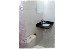 uma pequena casa de banho com lavatório e WC em Suítes de Setiba - HOSPEDARIA OCA RUCA em Guarapari