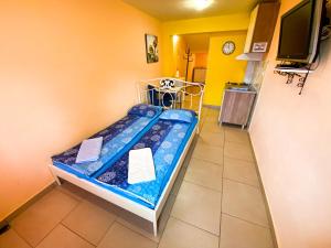 a small bed in a room with a tv at Synergy Deluxe Apartments in Sečovlje