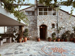 a stone building with a courtyard with potted plants at Andreas Village 2 in Achladies