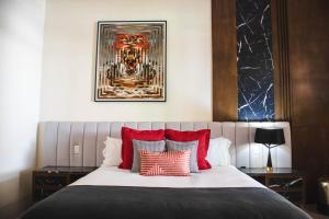 a bedroom with a large bed with red pillows at GALA Hotel Boutique in Guadalajara