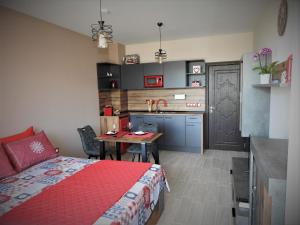 a bedroom with a bed and a table and a kitchen at Vintage Studio Mladost in Sofia